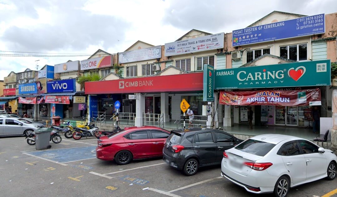 Sebaris lot kedai komersial di Malaysia menampilkan cawangan CIMB Bank berwarna merah sebagai tumpuan utama. Di kanannya terdapat Farmasi CARING berwarna hijau, dan di sebelah kirinya terdapat beberapa kedai telefon bimbit termasuk Vivo dan Samsung