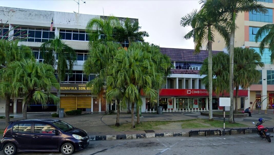 Pemandangan luar cawangan CIMB Bank di Batu Pahat, Malaysia. Bank ini terletak di tingkat bawah bangunan komersial bertingkat dengan papan tanda merah yang menonjol