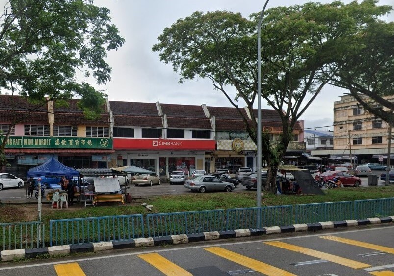 Pandangan aras jalan cawangan CIMB Bank yang terletak di deretan rumah kedai dua tingkat di Labis, Malaysia. Bank ini mempunyai papan tanda merah yang menonjol dan diapit oleh pasar mini dan perniagaan tempatan yang lain