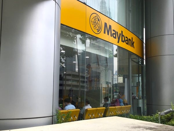 Pemandangan luar cawangan Maybank yang terletak di Menara Felda. Imej itu memaparkan papan tanda kuning khas bank dengan logo harimau di atas tingkap kaca yang besar. Di dalamnya, pelanggan dilihat duduk di kerusi menunggu berwarna kuning
