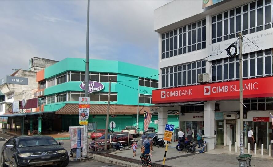 Pandangan aras jalan CIMB Bank dan cawangan CIMB Islamic bertingkat di Bahau, Malaysia. Bangunan putih itu mempunyai papan tanda merah yang menonjol dan lobi perbankan layan diri 24 jam