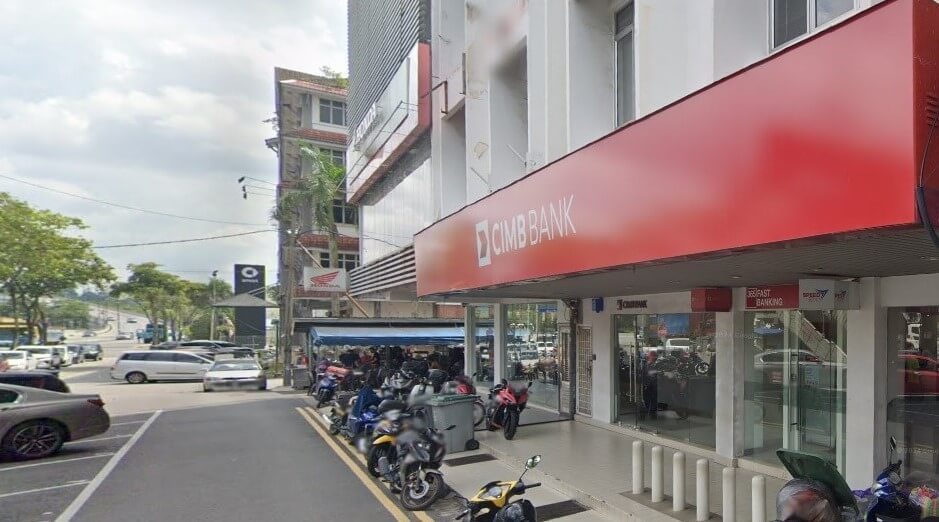 Gambar paras mata yang luas bagi cawangan CIMB Bank di Tampoi, Malaysia, yang memaparkan papan tanda kedai merah yang menonjol