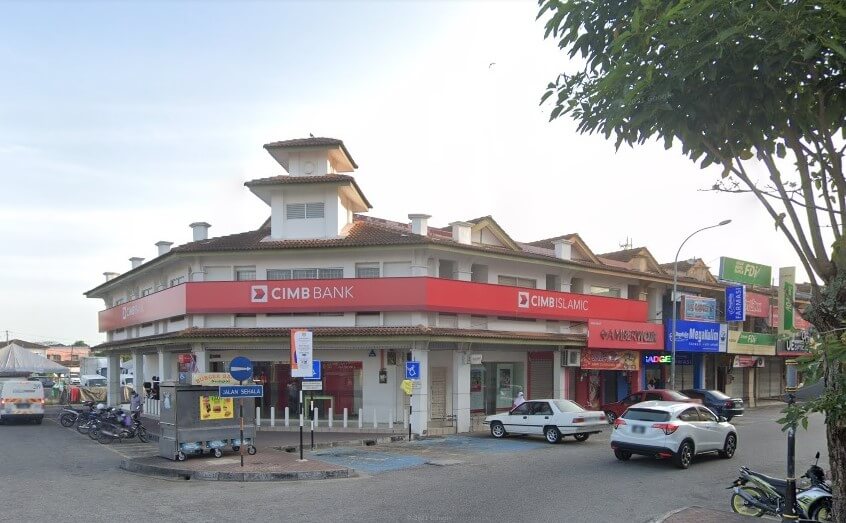 Pemandangan aras jalan sebuah CIMB Bank dan cawangan CIMB Islamic dua tingkat berwarna putih yang terletak di satu sudut di Kepala Batas, Malaysia. Bangunan ini mempunyai menara putih bertingkat yang tersendiri di atas bumbung dan papan tanda mendatar merah panjang yang merentangi bahagian hadapan bangunan