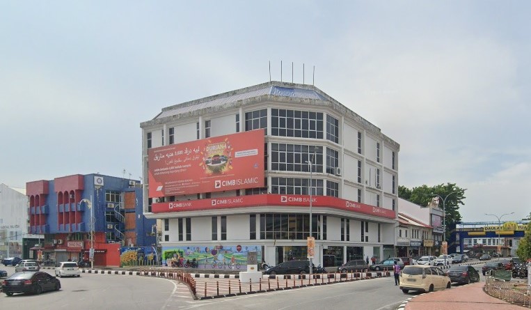 Sebuah bangunan bertingkat CIMB Bank dan CIMB Islamic yang terletak di sudut jalan di Kangar, Malaysia. Bangunan putih ini mempunyai papan iklan promosi oren yang besar di sisinya dan papan tanda berjenama merah yang melilit tingkat satu