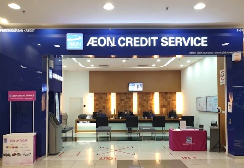 Pemandangan pintu masuk dan bahagian dalam pusat AEON Credit Service di Taiping, menunjukkan kaunter kakitangan, tempat duduk pelanggan dan papan promosi