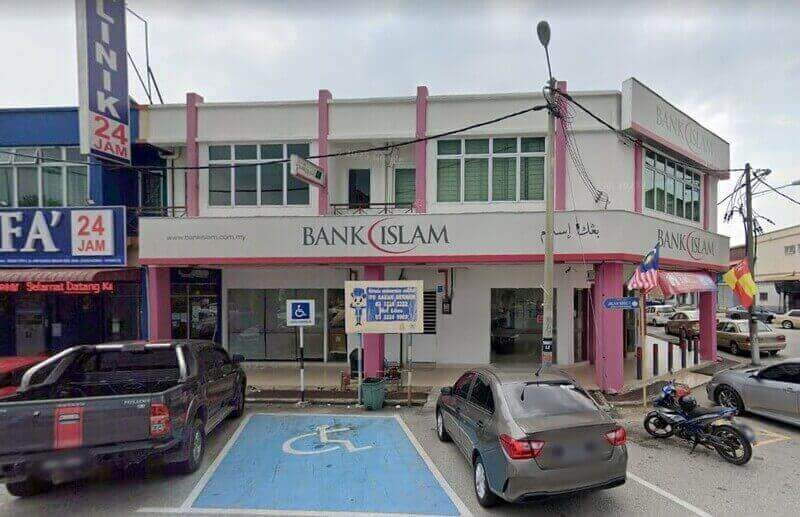 Pandangan luar Bank Islam Malaysia Berhad cawangan Sungai Besar, menampilkan bahagian hadapan berwarna putih dan merah jambu, pintu masuk aras jalan dan ruang letak kereta khas untuk orang kurang upaya di hadapan