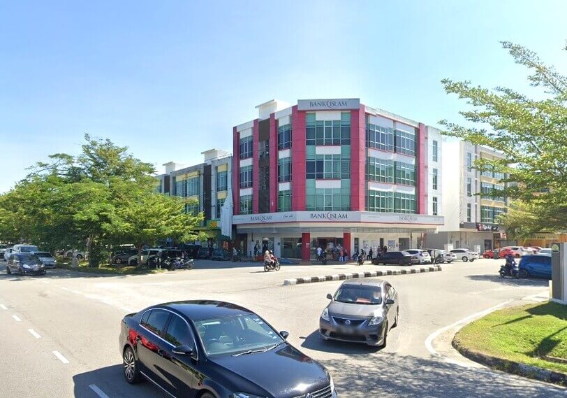 Sebuah bangunan cawangan Bank Islam bertingkat dengan bahagian hadapan berwarna merah dan putih, terletak di sudut jalan di Kuala Nerus, Terengganu. Imej tersebut menunjukkan pintu masuk bank di aras tanah dengan kereta dan motosikal yang diletakkan berdekatan