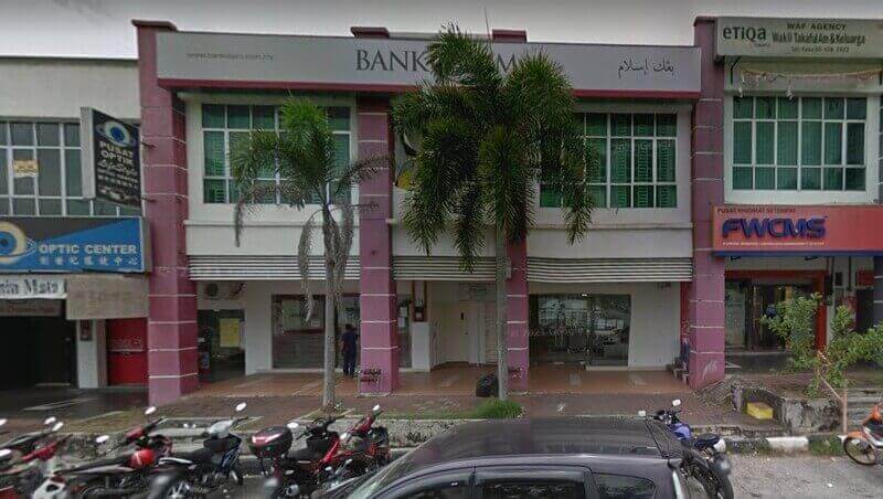 Pandangan luar cawangan Bank Islam Malaysia Berhad Meru Raya di Ipoh, menampilkan kedai berwarna merah putih bangunan, papan tanda dan tempat letak kereta tepi jalan di sekelilingnya