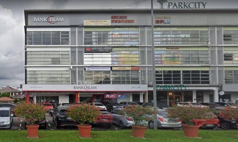 Cawangan Bank Islam Malaysia Berhad di Simpang Tiga terletak di dalam bangunan komersial Parkcity, menampilkan sebuah kedai dengan kereta yang diletakkan di tempat letak kereta dan pasu bunga di latar depan