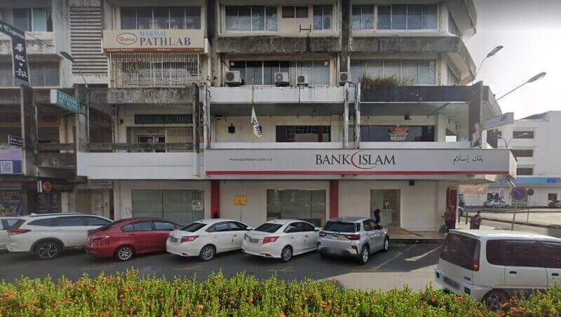 Cawangan Bank Islam Malaysia Berhad di hadapan kedai Tawau dengan kereta terparkir dan papan tanda Pathlab di bangunan komersial bertingkat