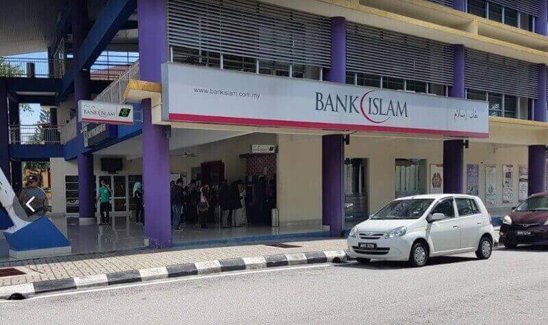Pandangan luar cawangan Bank Islam Malaysia Berhad di UiTM Shah Alam, menunjukkan pintu masuk utama, papan tanda dan kereta yang diletakkan di kampus