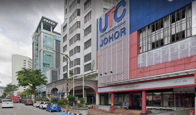 Pemandangan jalan cawangan Bank Islam yang terletak di UTC Johor (Pusat Transformasi Bandar) di Johor Bahru, memaparkan kedai bank berwarna merah dan putih di bawah papan tanda bangunan UTC Johor yang besar berwarna biru dan merah