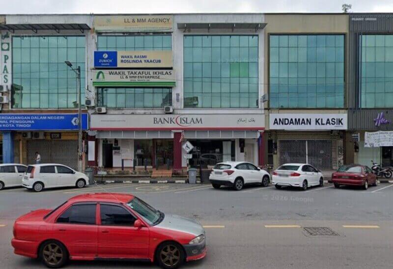 Pemandangan luar cawangan Bank Islam Malaysia Berhad di Kota Tinggi, terletak di deretan lot kedai dua tingkat moden dengan tingkap kaca hijau besar dan kereta diletakkan di hadapan