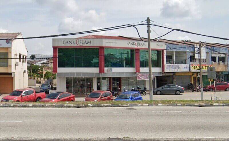 Pandangan luar cawangan Bank Islam Malaysia Berhad dua tingkat di Seri Manjung, Malaysia, menampilkan bahagian hadapan putih dan merah dengan tingkap besar berwarna hijau