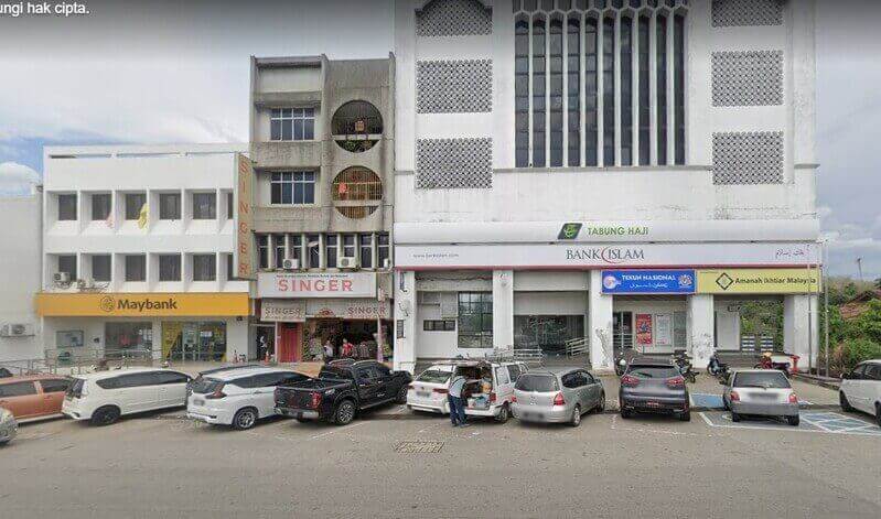 Pemandangan jalan bangunan komersial di Kuala Pilah yang menampilkan cawangan Maybank, Singer dan Bank Islam (yang turut menempatkan Tabung Haji, Tekun Nasional dan Amanah Ikhtiar Malaysia), dengan beberapa kereta diletakkan di hadapan