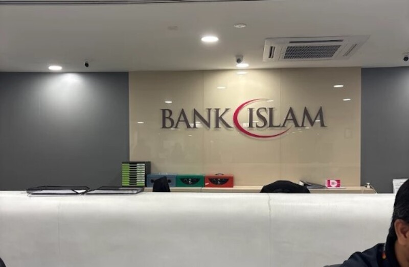 Bahagian dalam cawangan Bank Islam Malaysia Berhad di Jalan Tun Razak menunjukkan kaunter penerimaan tetamu yang anggun dan logo korporat yang dipasang pada panel dinding berwarna kuning air