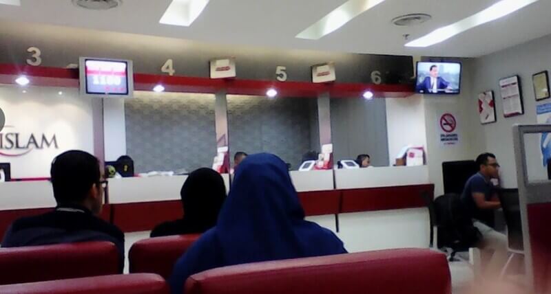 Pandangan dalaman cawangan Bank Islam Malaysia Berhad di G/GF Medan Mara menunjukkan pelanggan di kerusi menunggu merah menghadap kaunter perkhidmatan dengan stesen juruwang bernombor dan paparan giliran digital