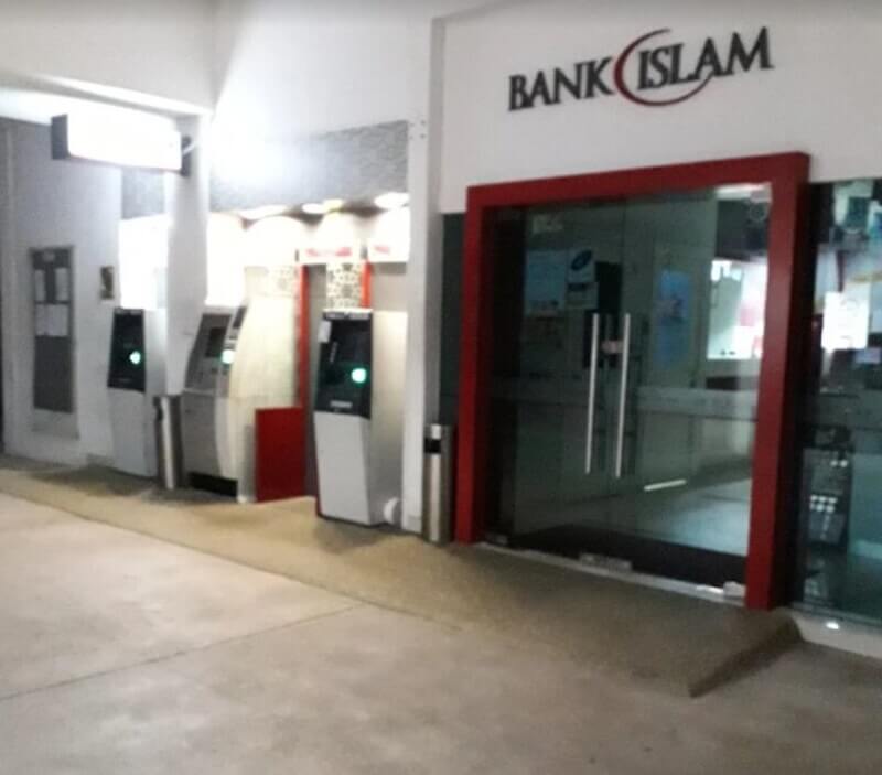 Pandangan luar cawangan Bank Islam yang menampilkan pintu masuk kaca dengan bingkai merah dan tiga mesin juruwang automatik (ATM) yang terletak di sepanjang dinding bersebelahan