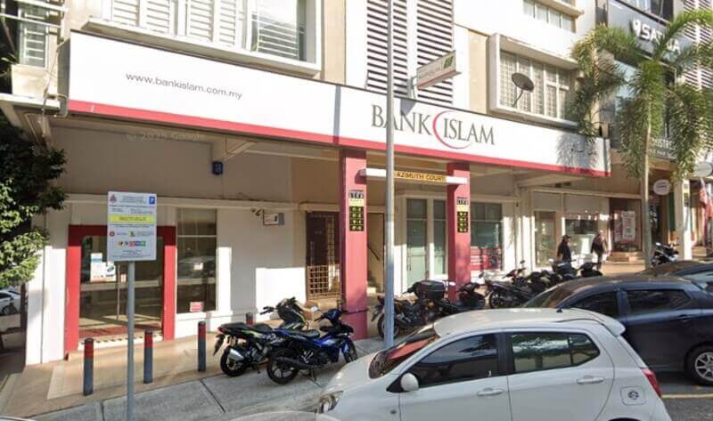 Bahagian luar cawangan Bank Islam di Wangsa Maju, Malaysia, memaparkan papan tanda putih dan merah yang menonjol di hadapan kedai dengan motosikal dan kereta yang diletakkan di latar depan